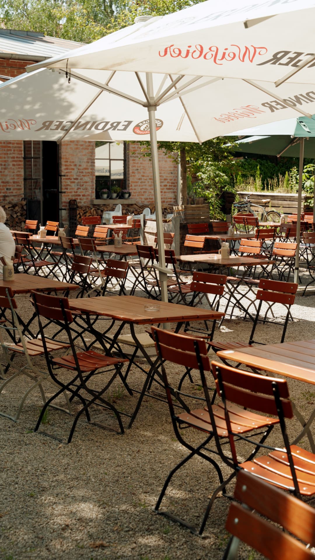 Biergarten mit Sonnenschirmen und Biergarnituren